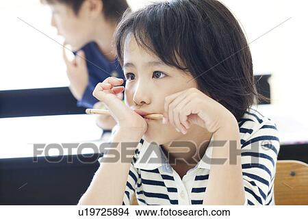 Picture - Girl thinking with pencil in her mouth. Fotosearch