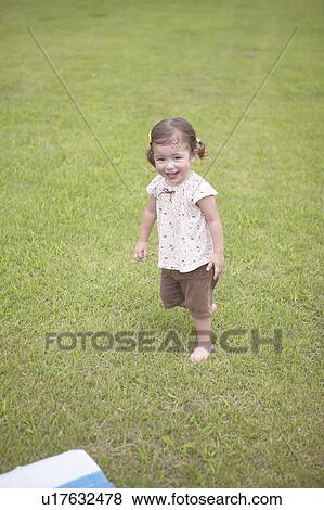 Girl walking on grass View Large Photo Image Stock Photo - Girl walking on grass. Fotosearch