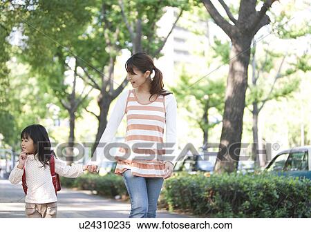 Stock Photography - Girl with backpack holding mother's hand. Fotosearch
