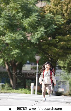 Stock Image - Girl with backpack running. Fotosearch