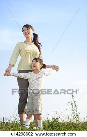 Girl with mother at riverbank, looking away View Large Photo Image Stock Image - Girl with mother at riverbank, looking away. Fotosearch