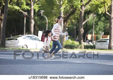 Girl with mother crossing street View Large Photo Image Stock Photo - Girl with mother crossing street. Fotosearch