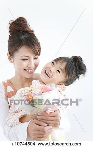 Girl with mother holding flower bouquet, white background View Large Photo Image Picture - Girl with mother holding flower bouquet, white background. Fotosearch
