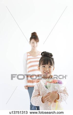 Stock Image - Girl with mother holding flower bouquet, white background. Fotosearch
