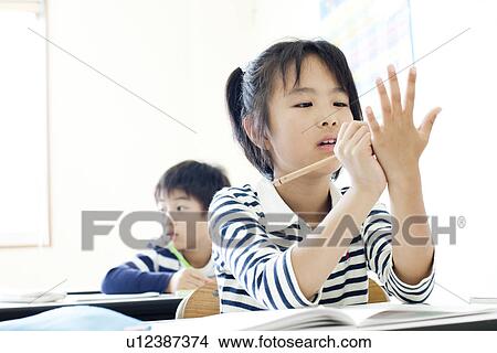 Picture - Girl writing on her hand. Fotosearch