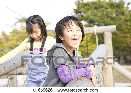 Stock Image - Girls on playground equipment. Fotosearch