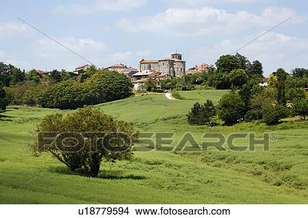 Picture - Green Field, Orange Roofed Houses in the Background, Charente, France. Fotosearch