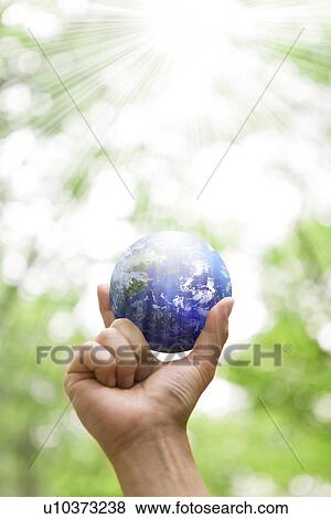 Stock Photo - Hand holding a globe. Fotosearch
