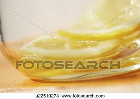 Stock Image - Jar of honey lemon preserve, close up. Fotosearch