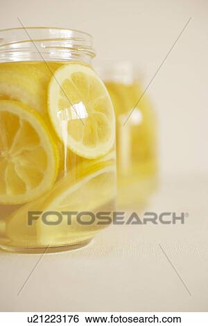 Stock Photograph - Jars of honey lemon preserve, close up, white background. Fotosearch