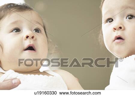 Stock Image - Low angle view of twin babies. Fotosearch