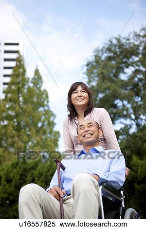 Stock Photography - Mature couple in park, man in wheelchair. Fotosearch