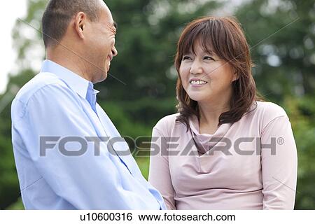 Stock Photograph - Mature couple in park, smiling. Fotosearch