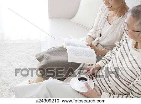 Stock Image - Mature couple sitting on sofa. Fotosearch