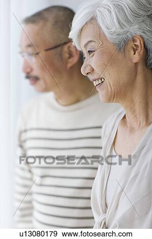 Stock Photo - Mature couple smiling and looking away. Fotosearch