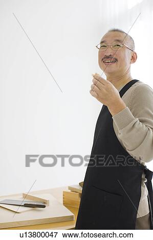 Mature man in apron smiling and looking away View Large Photo Image Stock Photo - Mature man in apron smiling and looking away. Fotosearch