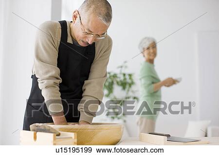 Stock Photo - Mature man making soba noodles, making dough. Fotosearch