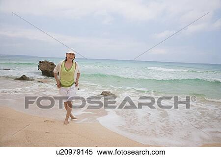 Mature woman standing at beautiful beach View Large Photo Image Stock Photography - Mature woman standing at beautiful beach. Fotosearch