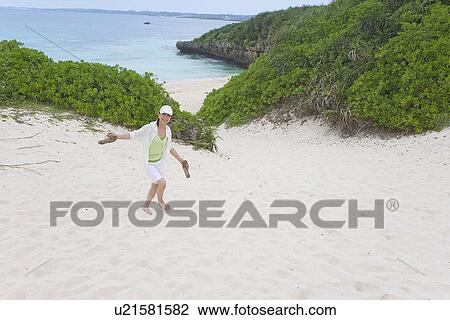 Mature woman walking on sand beach View Large Photo Image Stock Image - Mature woman walking on sand beach. Fotosearch