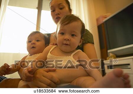 Mother holding twin babies View Large Photo Image Picture - Mother holding twin babies. Fotosearch