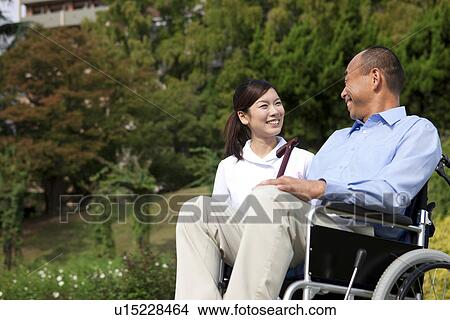 Picture - Nurse and man on wheelchair. Fotosearch