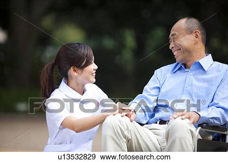 Stock Photo - Nurse and man on wheelchair. Fotosearch