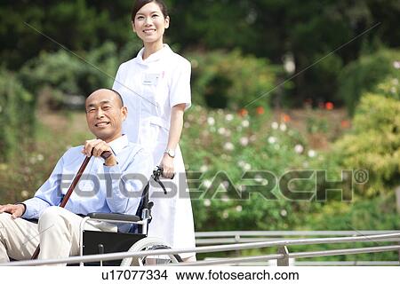 Picture - Nurse with a man on wheelchair. Fotosearch