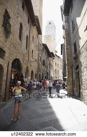 Stock Image - People in Narrow Alley, San Gimignano, Italy. Fotosearch