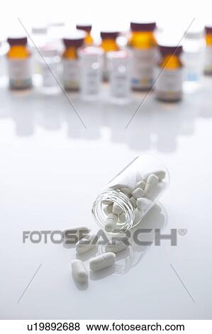 Stock Photo - Pills spilling from pill bottle. Fotosearch
