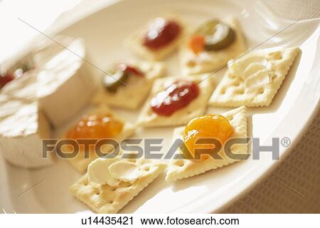 Stock Image - Plate of crackers with cream cheese and jam, close up, differential focus. Fotosearch