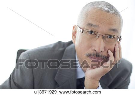 Portrait of businessman resting chin on hand, white background View Large Photo Image Stock Photo - Portrait of businessman resting chin on hand, white background. Fotosearch