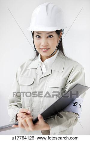 Stock Photograph - Portrait of female architect with a hardhat. Fotosearch