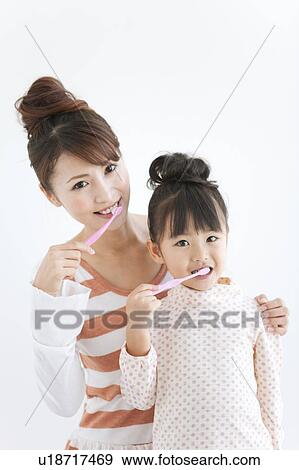 Portrait of girl and woman brushing teeth, white background View Large Photo Image Stock Photo - Portrait of girl and woman brushing teeth, white background. Fotosearch
