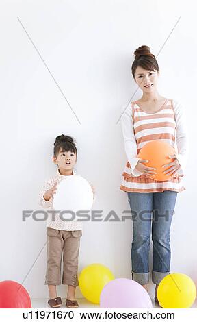 Portrait of girl and woman holding balloons, white background View Large Photo Image Stock Image - Portrait of girl and woman holding balloons, white background. Fotosearch