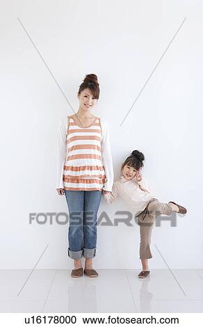 Portrait of girl and woman standing hand in hand, white background View Large Photo Image Stock Image - Portrait of girl and woman standing hand in hand, white background. Fotosearch
