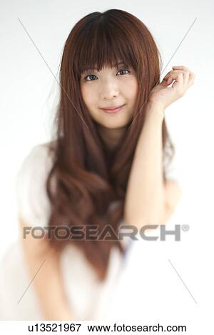Portrait of young woman, smiling, white background, differential focus View Large Photo Image Stock Photo - Portrait of young woman, smiling, white background, differential focus. Fotosearch