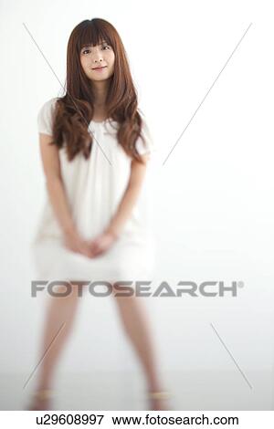 Stock Photo - Portrait of young woman, smiling, white background, differential focus. Fotosearch