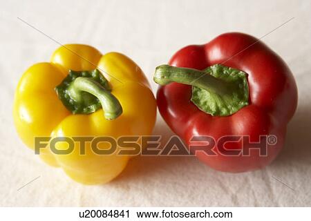 Stock Image - Red and yellow bell peppers, close up, white background. Fotosearch