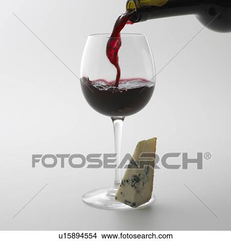Picture - Red wine pouring into grass, white background. Fotosearch