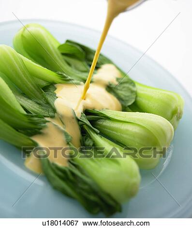 Stock Photo - Salad dressing being poured on Bok Choy. Fotosearch