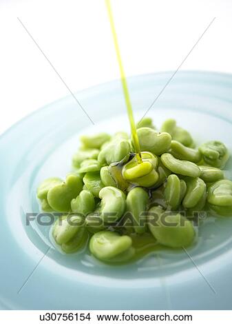 Picture - Salad dressing being poured on Fava Beans. Fotosearch