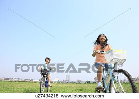 Stock Photo - Siblings riding bicycles. Fotosearch