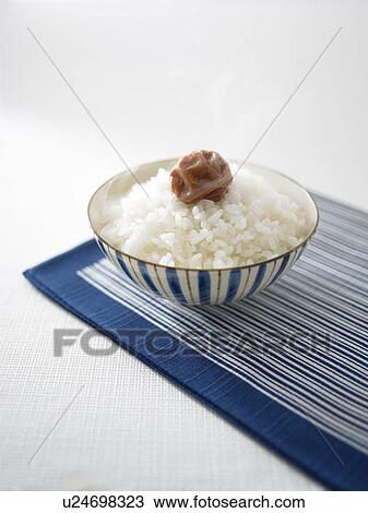 Stock Image - Steamed rice and pickled plum in a bowl. Fotosearch