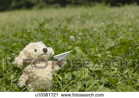 Stock Image - Stuffed Toy Holding Paper Airplane. Fotosearch