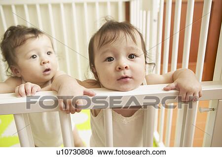 Stock Photo - Twin babies in cot. Fotosearch
