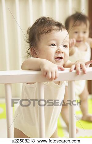 Stock Photo - Twin babies in cot. Fotosearch