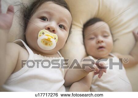 Stock Photograph - Twin babies laying. Fotosearch