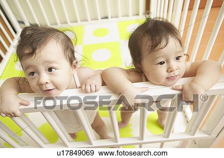 Stock Photo - Twin babies on the bed. Fotosearch