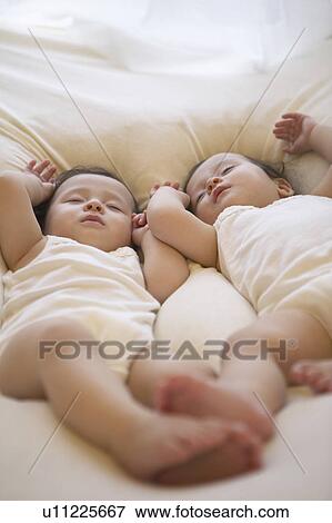 Twin baby girls sleeping View Large Photo Image Stock Photo - Twin baby girls sleeping. Fotosearch