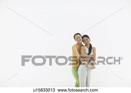 Two young woman embracing View Large Photo Image Stock Image - Two young woman embracing. Fotosearch
